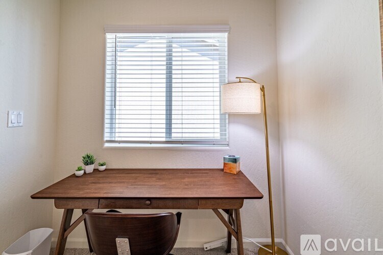 A wooden table with a lamp and a plant on it.