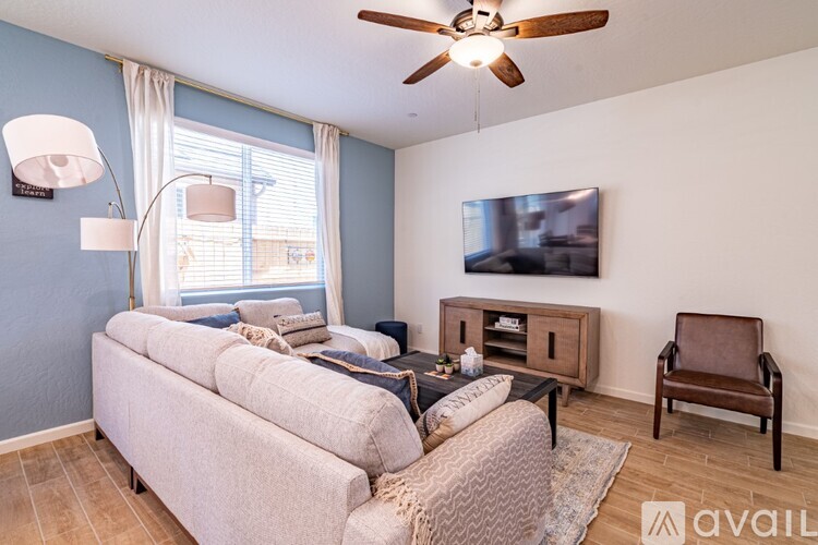 A living room with a couch, chair, and television.