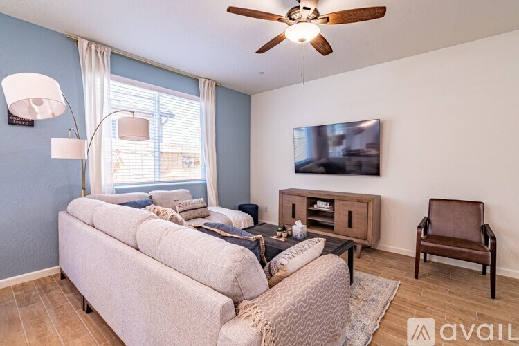 A living room with a couch, chair, and television.