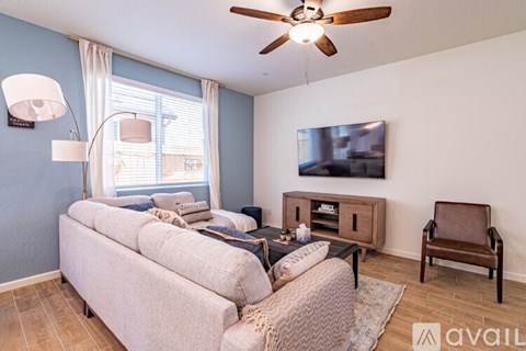 A living room with a couch, chair, and television.