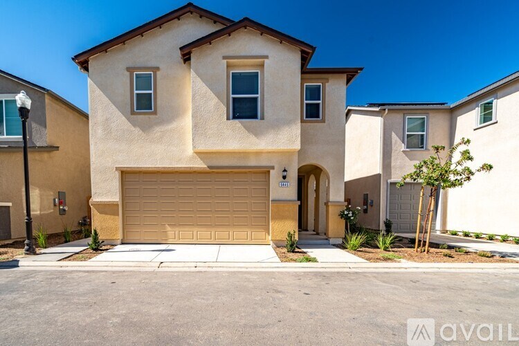 A beige house with a brown garage door in front of it.