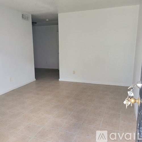 A room with tiled flooring and a door in the background.