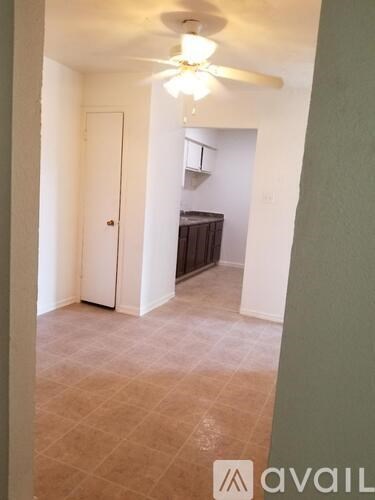 A room with a ceiling fan and a door.