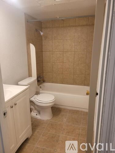 A bathroom with a toilet, sink, and bathtub.
