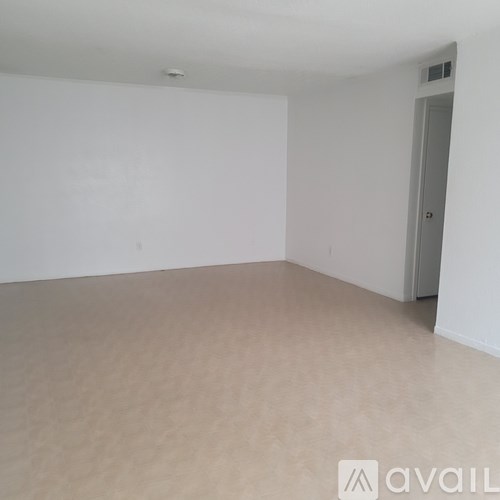 A room with a carpeted floor and a door.