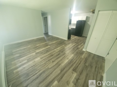 A room with wooden flooring and a white door.