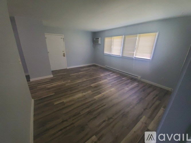 A room with wooden flooring and a white door.