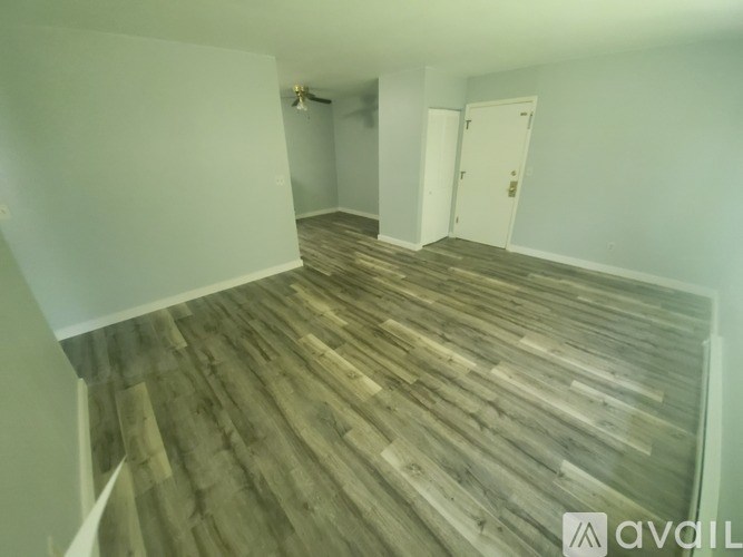 A room with wooden flooring and white walls.