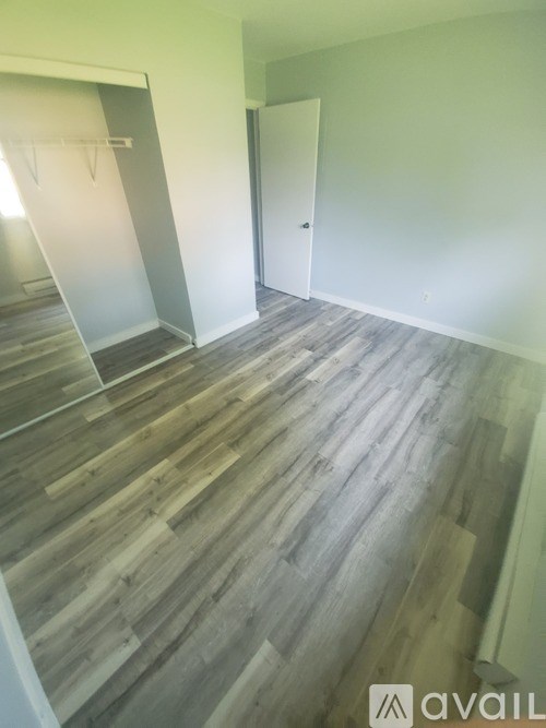 A room with wooden flooring and a white door.