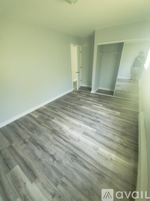 A room with wooden flooring and white walls.