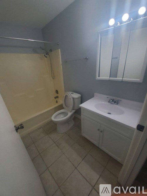 A bathroom with a toilet, sink, and shower.
