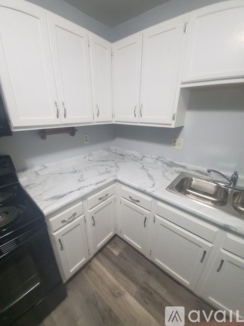A kitchen with white cabinets and a black oven.