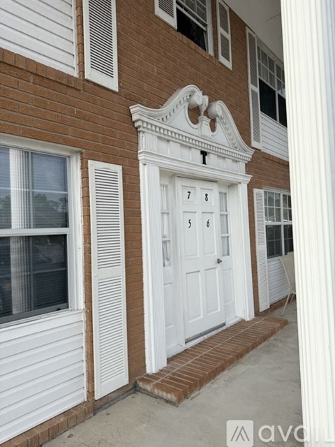 A white door with the number 7 on it is on a brick building.