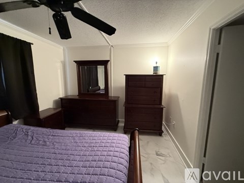 A bedroom with a bed, dresser, and mirror.