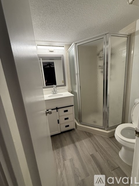 A bathroom with a toilet, sink, and shower.