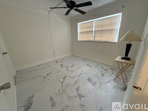 A room with a marble floor and a ceiling fan.