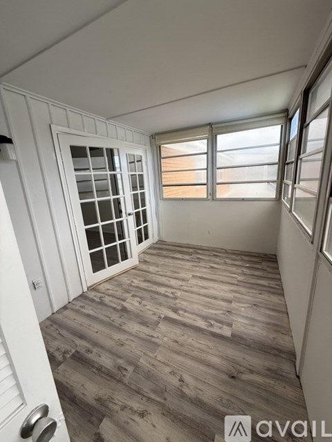 A room with wooden flooring and white walls.
