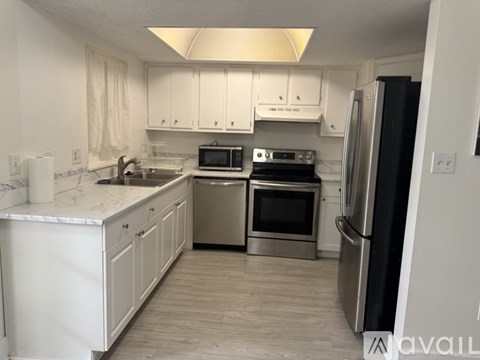 A kitchen with white cabinets and stainless steel appliances.