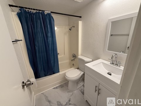 A bathroom with a toilet, sink, and shower.