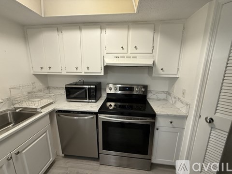 A kitchen with white cabinets and stainless steel appliances.