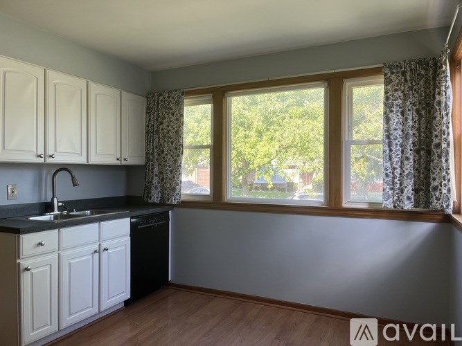 A kitchen with white cabinets and a black countertop.