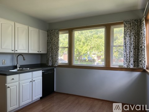 A kitchen with white cabinets and a black countertop.