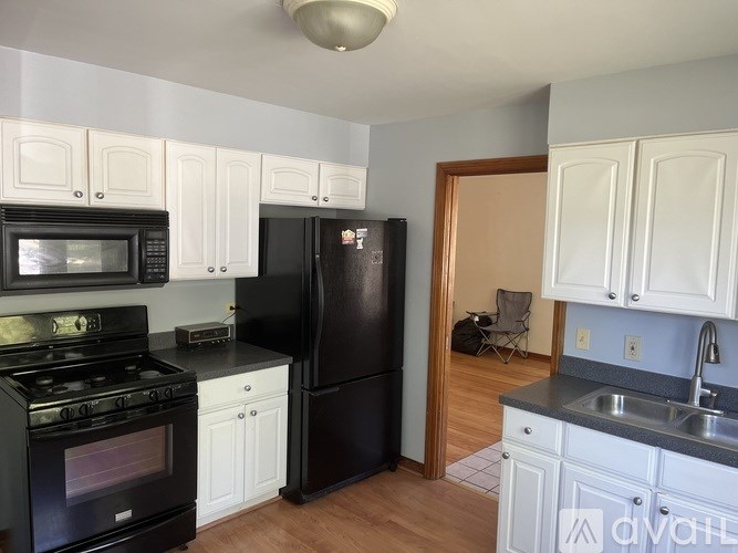 A kitchen with black appliances and white cabinets.