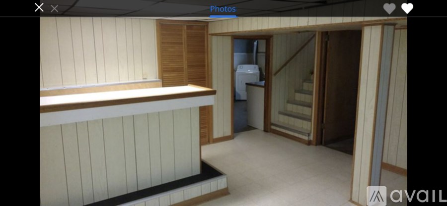 A room with a staircase and a counter.