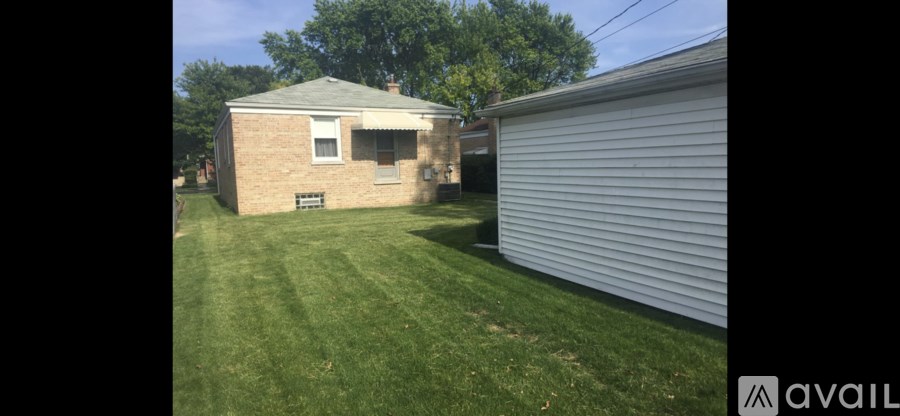 A backyard with a house and a garage.