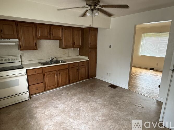 A kitchen with wooden cabinets and a stainless steel oven.