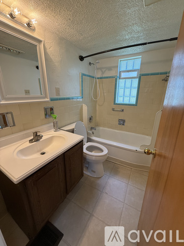 A bathroom with a toilet, sink, and bathtub.