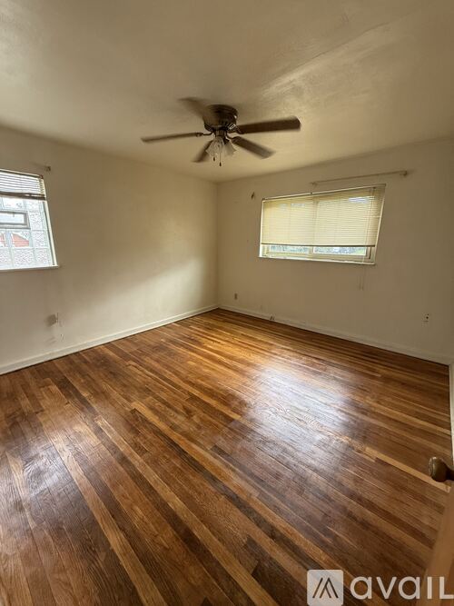 A room with wooden flooring and a ceiling fan.