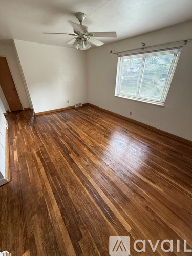 A room with wooden flooring and a ceiling fan.