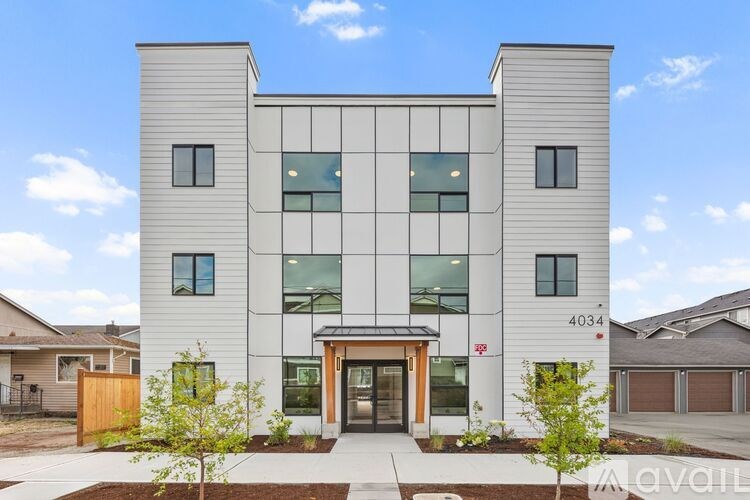 A modern two-story house with a white exterior and a large glass window on the second floor.