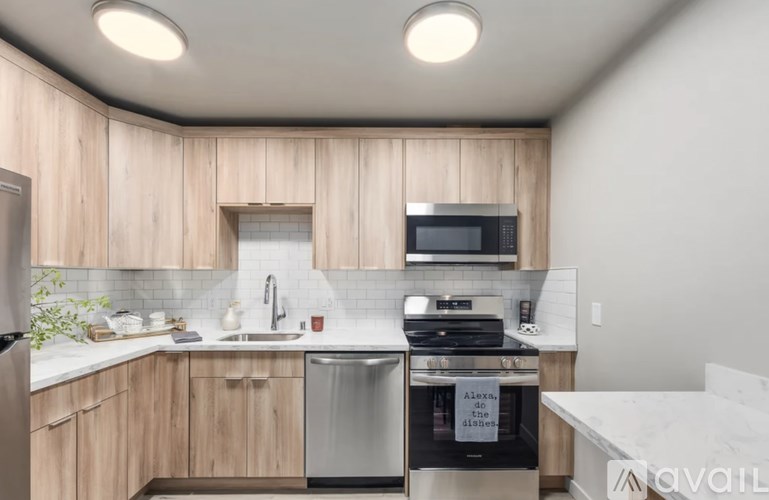 A kitchen with wooden cabinets and a stainless steel dishwasher.