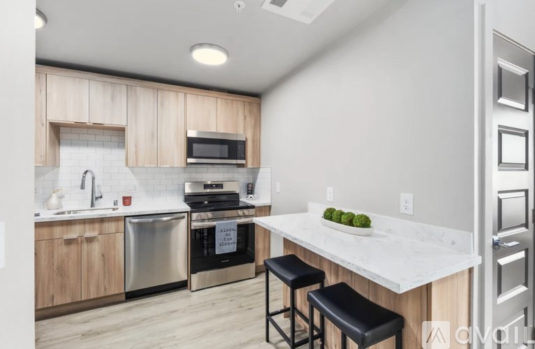 A kitchen with a white countertop and wooden cabinets.