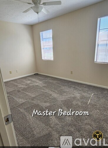 A master bedroom with a carpeted floor and a ceiling fan.