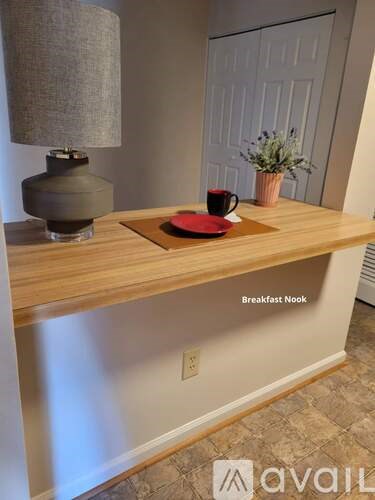 A breakfast nook with a lamp and a cup on the counter.