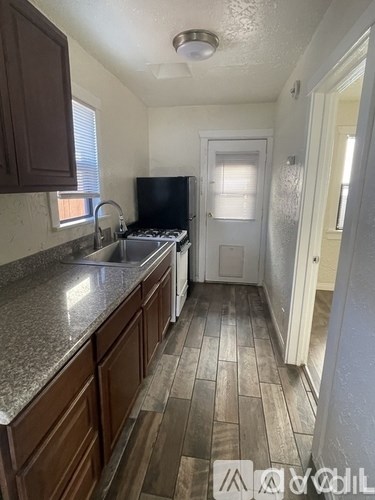 A kitchen with wooden cabinets and a black stove top oven.