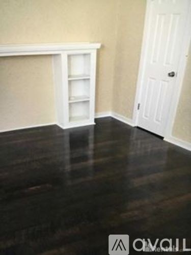A room with a white door and a white cabinet with a shelf.