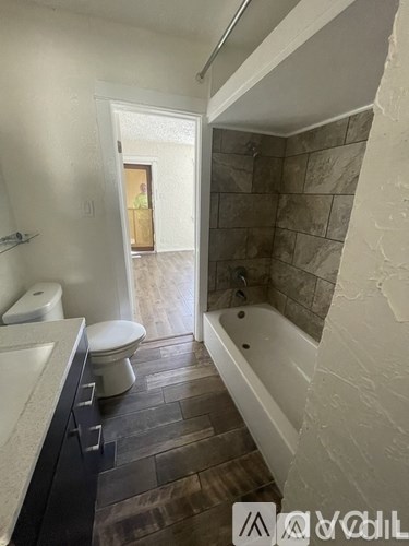 A bathroom with a toilet, sink, and bathtub.