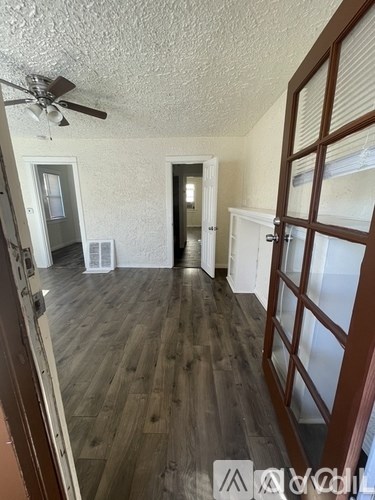 A room with wooden floors and a ceiling fan.