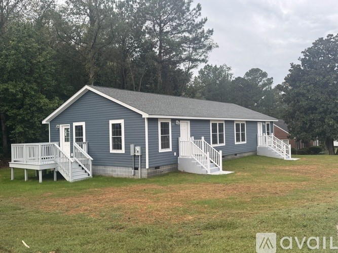A blue house with a porch and a covered deck.