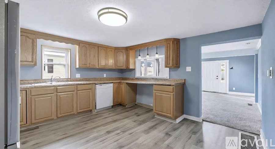 A kitchen with wooden cabinets and a white dishwasher.