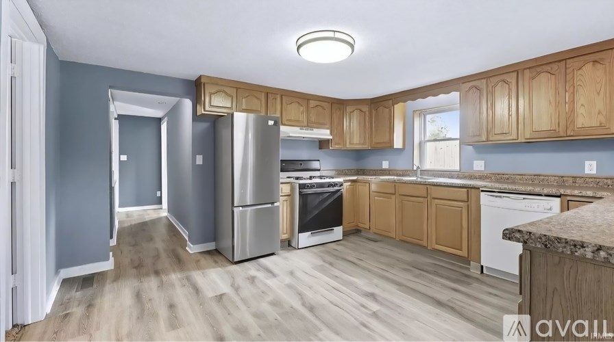 A kitchen with wooden cabinets and a refrigerator.