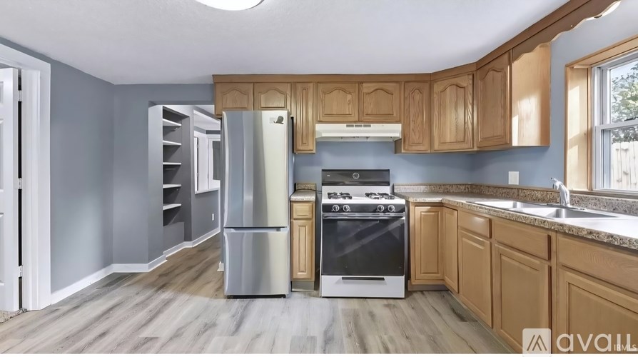 A kitchen with wooden cabinets and a stainless steel refrigerator.