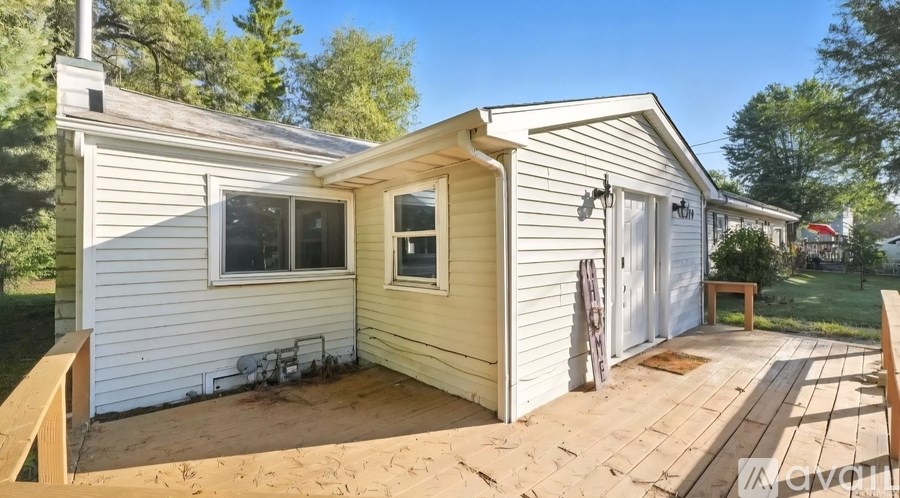 A small house with a wooden deck in front.