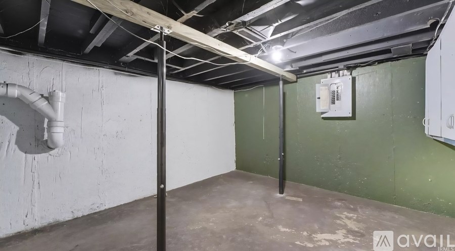 A room with a white pipe on the wall and a grey floor.