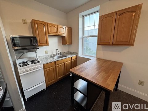 A kitchen with wooden cabinets and a black stove top.