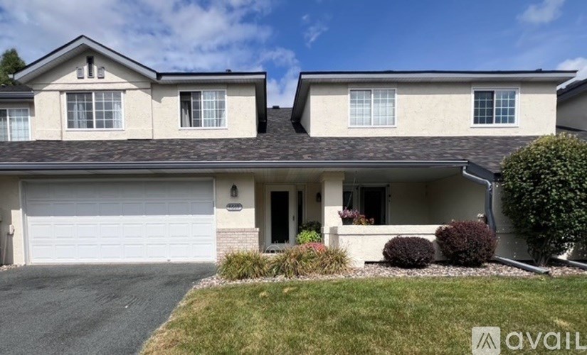 A two-story house with a garage is for sale.